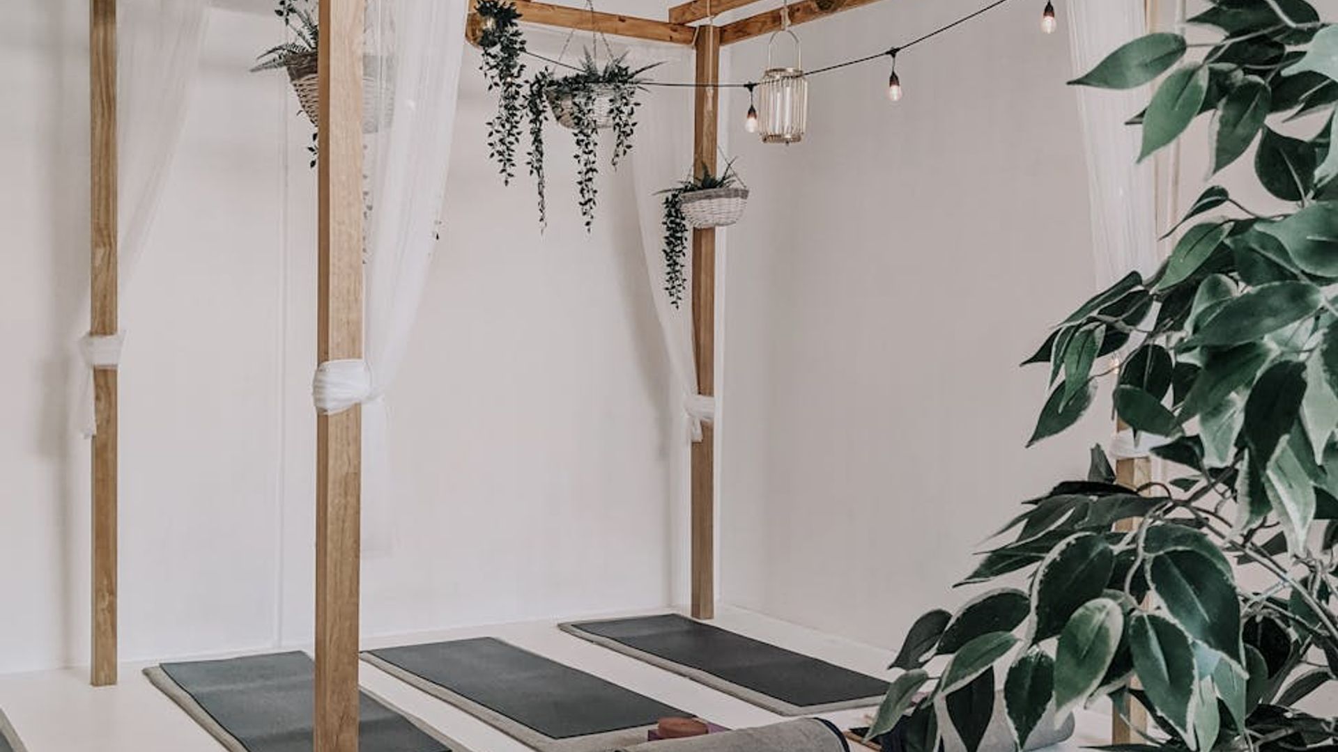Minimalist yoga studio with natural light and wooden floor.