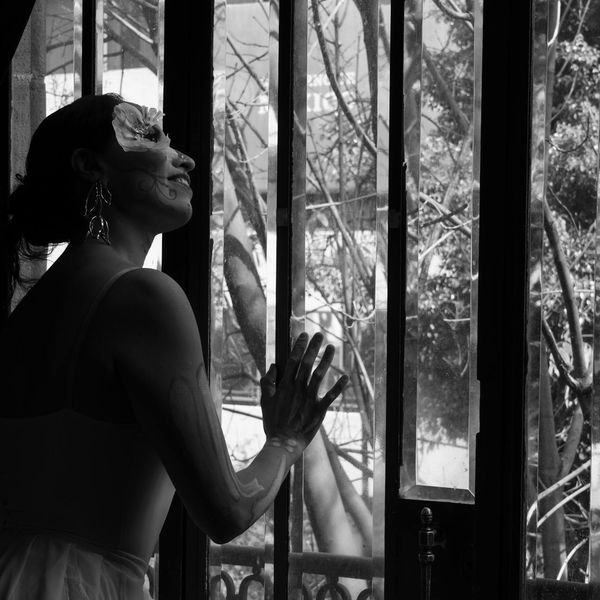 Stretching pose silhouette against a window.
